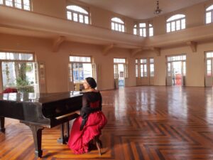 Júlia da Costa tocando o piano centenário do club Litterario